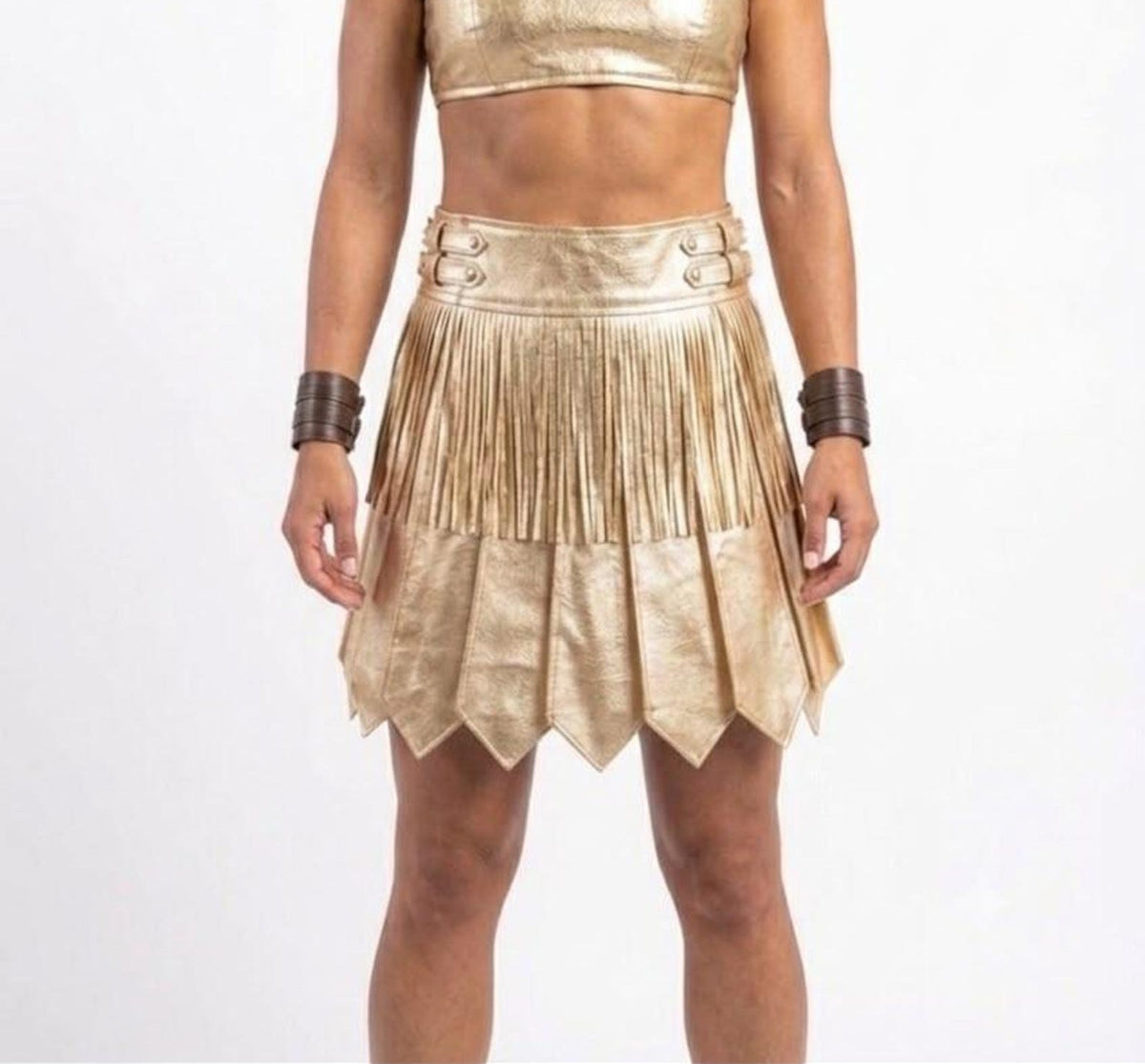 Gold gladiator kilt with metallic finish, pleated detailing, decorative waist straps, and pointed hem panels